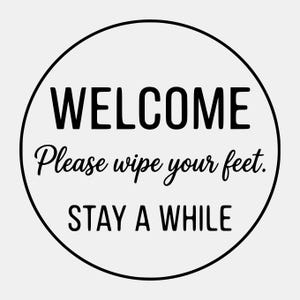 Puede incluir: Un letrero redondo con borde negro y fondo blanco. La palabra "WELCOME" está en la parte superior en letras mayúsculas negras en negrita. Debajo, en una fuente de escritura, dice "Please wipe your feet". En la parte inferior, dice "STAY A WHILE".