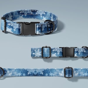 May include: Blue dog collar with a snowflake pattern. The collar has a black plastic buckle and a metal D-ring. The image shows the collar in three different sizes.