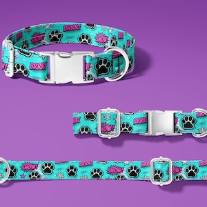 May include: Three dog collars with a teal background and a repeating pattern of black paw prints, snowflakes, and comic book style text that reads "BRRR!" and "SNOW!". The collars have silver metal buckles.