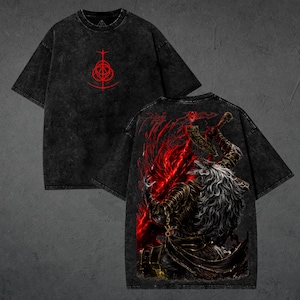 May include: Black t-shirt with a distressed wash effect. The front features a red graphic symbol, while the back displays a detailed illustration of a warrior with a red and black fiery background. The shirt has short sleeves and a crew neck.