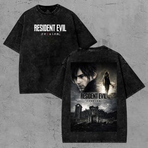 May include: Black, oversized t-shirt featuring the text "RESIDENT EVIL requiem" in white. The back of the shirt displays a graphic of a man and a woman with the text "RESIDENT EVIL requiem" and a building.