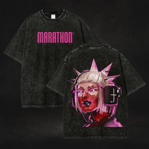 May include: Black acid wash t-shirt with the word "MARATHON" in pink across the chest. The back features a graphic of a woman with a futuristic headpiece and a coffee cup, in shades of pink and red.