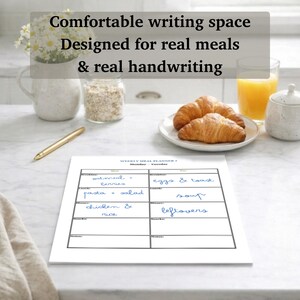 May include: A weekly meal planner with handwritten meal entries. The planner includes sections for breakfast, lunch, dinner, and snacks. Text on the image reads: "Comfortable writing space. Designed for real meals & real handwriting."