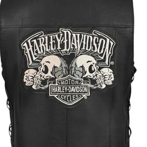 Op de afbeelding: Zwarte leren vest met een Harley-Davidson-patch met een schedelontwerp. De patch bevat het Harley-Davidson-logo en de tekst "MOTOR HARLEY-DAVIDSON CYCLES". Het vest heeft veters aan de zijkanten.