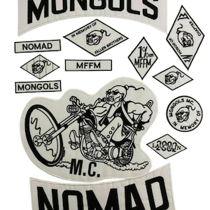 Puede incluir: Un conjunto de parches bordados blancos con texto y gráficos negros. Los parches incluyen la palabra "MONGOLS" en una pancarta curva, "NOMAD", y un motero en una motocicleta. Otros parches tienen texto como "IN MEMORY OF" y "MFFM".