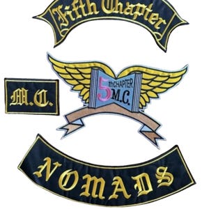 May include: Set of four embroidered patches. The patches are black with gold lettering and accents. The patches include the phrases "Fifth Chapter", "M.C.", and "Nomads". One patch features a winged design with the text "5th CHAPTER M.C."