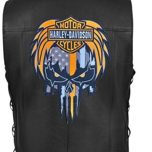 May include: Black leather vest featuring a Harley-Davidson Cycles patch with a skull design. The patch incorporates the American flag colors of blue, white, and orange. The vest has side lacing details.