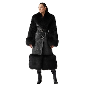 Puede incluir: Abrigo negro largo con cuello, puños y dobladillo de piel. El abrigo presenta un cinturón de cuero con hebilla y un estampado floral en relieve en el cuerpo. La persona lleva botas negras de tacón alto.