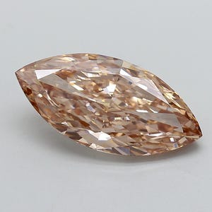 May include: A marquise-cut gemstone with a light champagne or peach-coloured hue. The stone features a faceted surface that creates a series of geometric reflections and light refractions across its elongated, pointed oval shape and smooth edges.