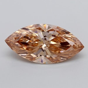 May include: A marquise-cut gemstone with a light champagne or peach-coloured hue. The stone features a symmetrical, elongated oval shape with pointed ends and numerous triangular facets that create a complex, reflective pattern across its surface.