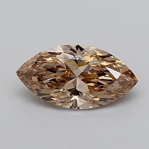 May include: A marquise-cut gemstone with a light brown, champagne-coloured hue. The stone features a faceted surface that creates a symmetrical, pointed oval shape with intricate geometric light reflections across its polished, translucent body.