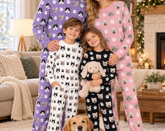 May include: Matching long-sleeve pajama sets featuring repeating patterns of cat faces and paw prints. The adult sets are purple and pink, while the children's sets are white and black. Each set includes a crew-neck top and matching pants.