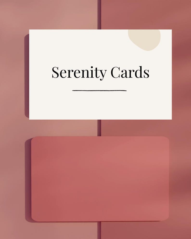 Op de afbeelding: Een witte kaart met de tekst "Serenity Cards" en een horizontale lijn eronder, tegen een roze achtergrond. Onder de kaart bevindt zich een effen, afgeronde rechthoekige vorm in een bijpassende roze tint. Een beige cirkel bevindt zich in de rechterbovenhoek.
