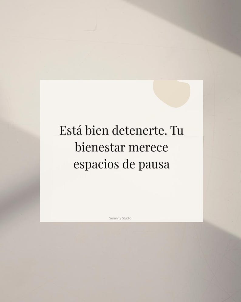 Op de afbeelding: Een witte vierkante kaart met de tekst "Est&aacute; bien detenerte. Tu bienestar merece espacios de pausa" in het zwart. De kaart heeft een minimalistisch ontwerp met een beige achtergrond en een kleine beige vorm in de rechterbovenhoek. De woorden "Serenity Studio" staan onderaan.