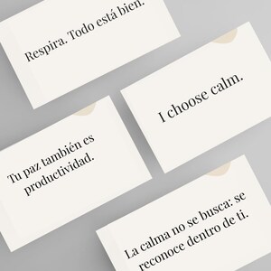Op de afbeelding: Vier rechthoekige kaarten met inspirerende citaten in het Engels en Spaans. De kaarten zijn gebroken wit met een lichtbeige designelement in de rechterbovenhoek. De tekst bevat "I choose calm" en "Adem in. Alles is goed."