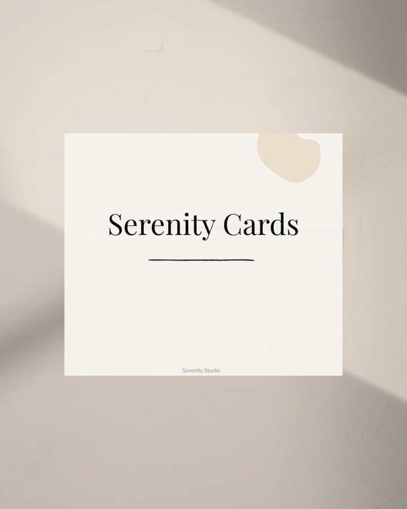 Op de afbeelding: Een vierkante, gebroken witte kaart met de woorden "Serenity Cards" in een schreefletter, onderstreept met een dunne zwarte lijn. De woorden "Serenity Studio" staan in kleinere letters onderaan. Een beige abstracte vorm bevindt zich in de rechterbovenhoek.