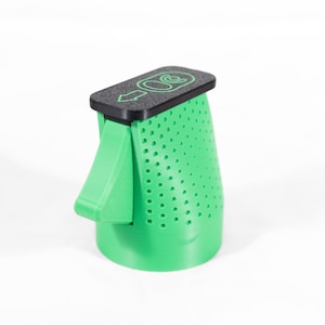 May include: A green, perforated, cone-shaped object with a black top. The top has a green graphic and arrow. A green handle extends from the side. The object is on a white background.