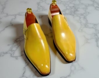 May include: A pair of bright yellow leather dress shoes with a pointed toe and a buckle closure. The shoes have a glossy finish and a dark sole. The interior of the shoes is a reddish-brown color.