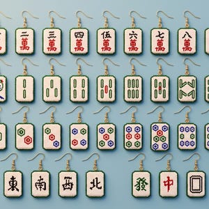 May include: A collection of rectangular earrings featuring beaded designs inspired by mahjong tiles. Each earring displays unique symbols, numbers, or patterns in red, green, blue, and black on a white background, finished with gold-toned hooks.