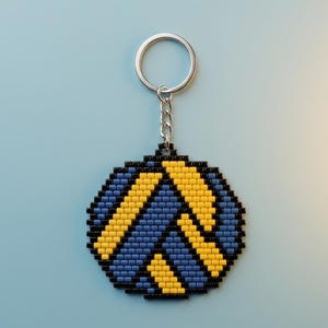 May include: A circular keychain crafted from small, square beads in a geometric pattern. The design features alternating diagonal stripes of bright yellow and muted blue, all outlined and bordered by a solid frame of black beads with a metal ring.