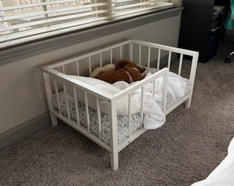 Cama elevada para cães com grades laterais, estrutura de metal e cama de madeira para animais de estimação.