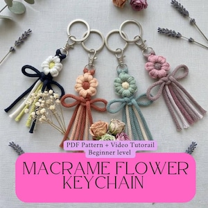 以下が含まれることがあります： 白、ピーチ、シーフォームグリーン、ピンクの4つのマクラメフラワーキーホルダー。各キーホルダーは花のモチーフ、リボン、ぶら下がっているコードが特徴です。画像にはドライフラワーと「MACRAME FLOWER KEYCHAIN」の文字も含まれています。