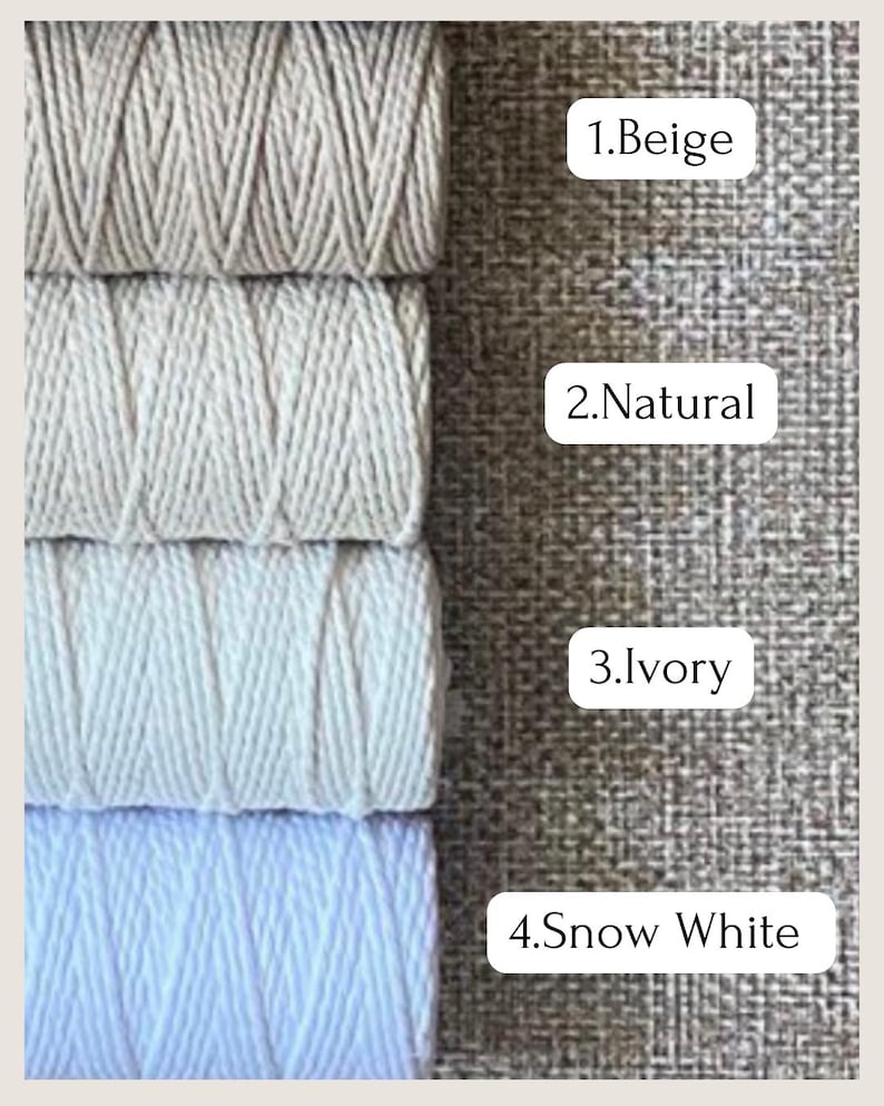 May include: Four spools of macrame cord in varying shades of white and beige. The colors are labeled: Beige, Natural, Ivory, and Snow White. The cord is tightly wound, showing the texture of the material.