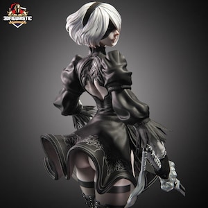 May include: A detailed figurine of a character with white hair, a black blindfold, and a black outfit. The figure is holding a silver sword. The outfit has intricate detailing and a flared skirt. The figurine is posed with a dynamic stance.