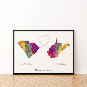 May include: A framed print featuring the states of South Carolina and West Virginia in a vibrant, multi-colored marbled pattern. A thin line connects the two states, forming a heart shape above them. The text reads South Carolina, West Virginia, and Home to Home.