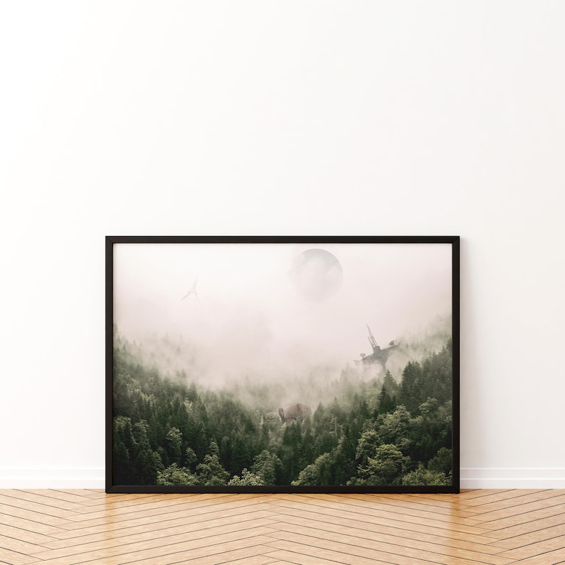 May include: A framed horizontal wall art print featuring a dense green forest landscape shrouded in thick white fog. A pale circular moon hangs in the sky above the treetops, with a faint silhouette of a bird and a distant structure visible.