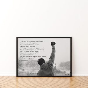 May include: Black and white framed print featuring a motivational quote from Rocky Balboa. The image shows a person with their fist raised in the air, with a snowy outdoor scene in the background. The quote is written in a script font.