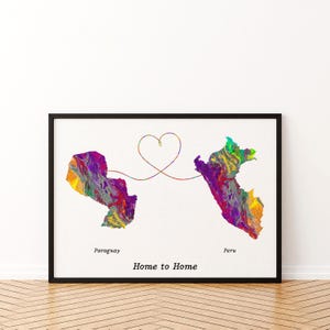 May include: A framed art print featuring colorful map outlines of Paraguay and Peru, connected by a heart-shaped line. The words "Paraguay", "Peru", and "Home to Home" are printed below the maps. The maps are filled with vibrant hues.