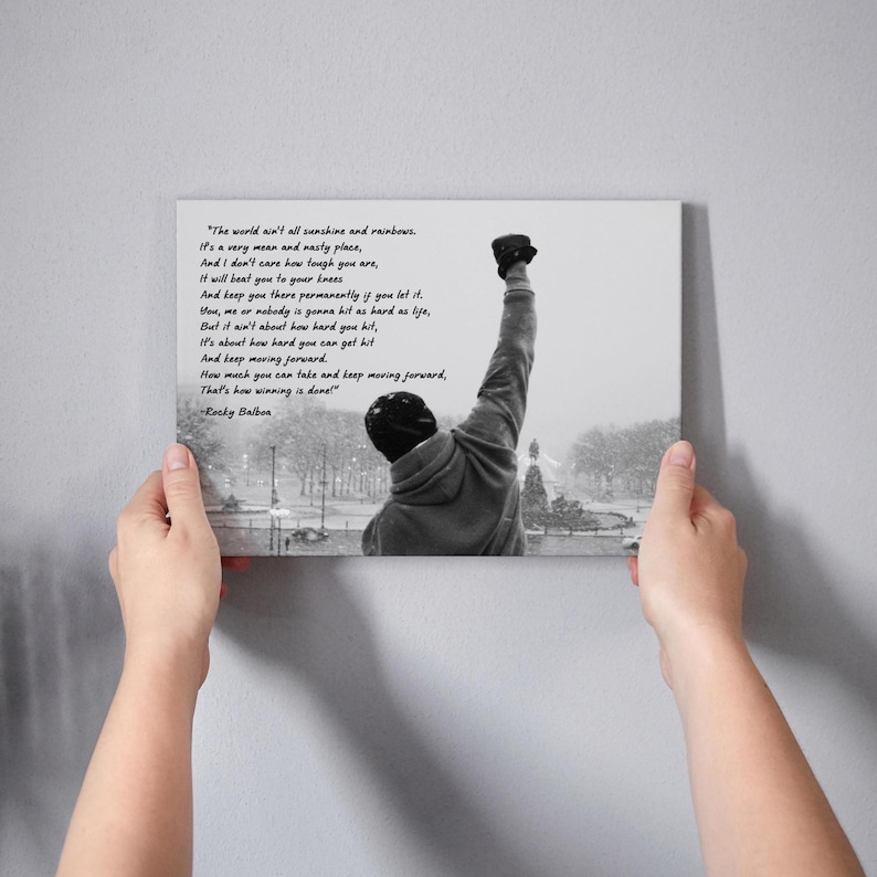 May include: A black and white canvas print featuring a motivational quote from Rocky Balboa. The image shows a figure with their fist raised in the air. The quote is displayed in a clear, easy-to-read font.