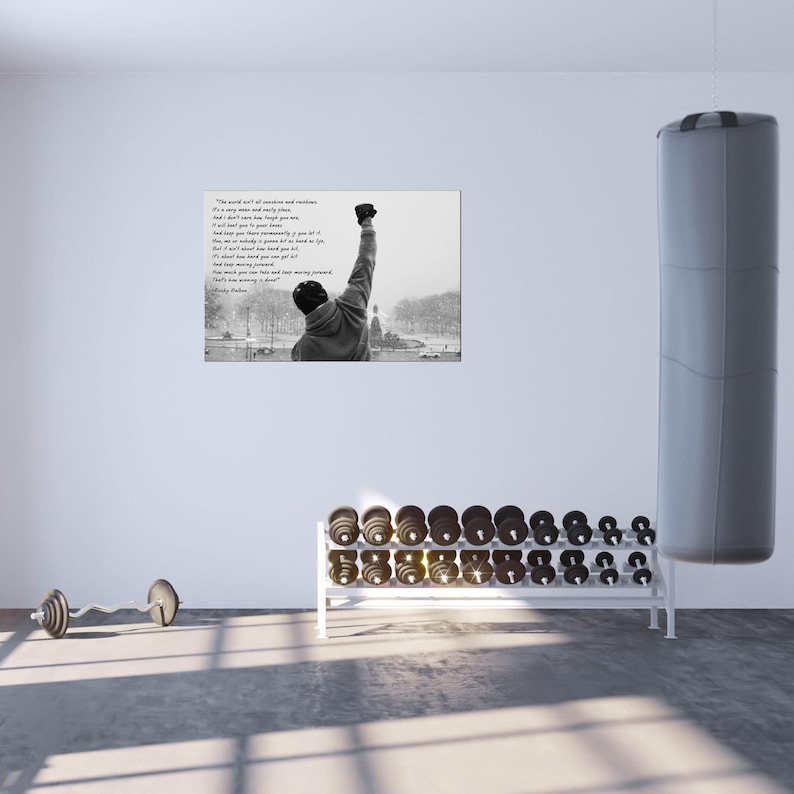 May include: A black and white framed print of a man with his fist raised in the air. The print is in a gym setting with dumbbells and a punching bag. Text on the print reads "The world ain't all sunshine and rainbows."