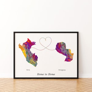 May include: A framed print featuring colorful abstract maps of Peru and Paraguay connected by a heart-shaped line. The words "Peru", "Paraguay", and "Home to Home" are printed below the maps. The artwork is set against a white background.