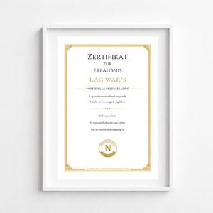 May include: A framed certificate with gold detailing and black text. The certificate reads "ZERTIFIKAT ZUR ERLAUBNIS LAG WAR'S" and includes additional text in German. The frame is white.