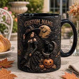 May include: A black ceramic mug featuring a raised relief design of a witch in a gown, a black cat on a crescent moon, a jack-o'-lantern, and a full moon. The text CUSTOM NAME is printed in gold at the top, surrounded by spiderwebs and roses.