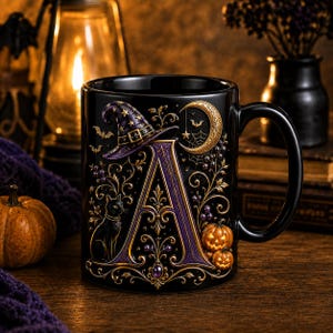 May include: A black ceramic mug featuring a large, ornate letter A in purple and gold. The design includes a witch hat, a black cat, two small pumpkins, a crescent moon, spider webs, and bats, all rendered in a detailed, raised-relief style.