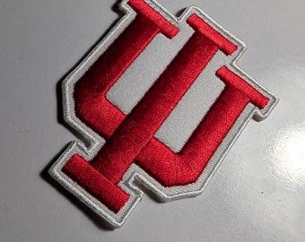 May include: Embroidered patch featuring a red and white design. The patch has a red "IU" logo, with a white background and a white border. The patch is likely for apparel or accessories, and is a collegiate item.