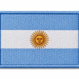 May include: Embroidered patch featuring the flag of Argentina. The design includes a light blue background with a white horizontal stripe in the center. The center of the white stripe features a golden sun with a face.