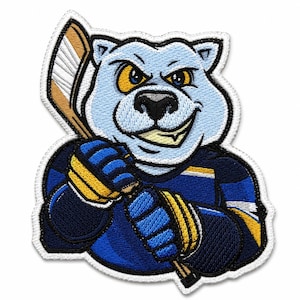 May include: An embroidered patch featuring a light blue polar bear mascot wearing a dark blue hockey jersey with yellow and white accents. The bear holds a wooden hockey stick with both hands, displaying a determined expression with yellow eyes.