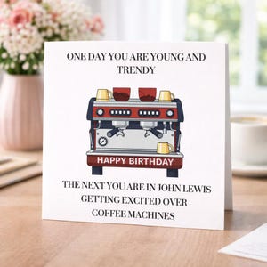 May include: A white greeting card featuring a graphic of a red and grey espresso machine with yellow and dark red cups. The text reads: ONE DAY YOU ARE YOUNG AND TRENDY, HAPPY BIRTHDAY, THE NEXT YOU ARE IN JOHN LEWIS GETTING EXCITED OVER COFFEE MACHINES.
