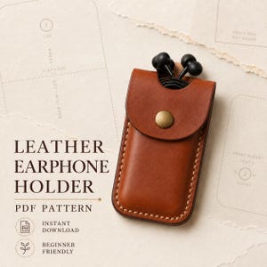 May include: A tan leather earphone holder with a brass snap button closure, containing black wired earbuds. The text LEATHER EARPHONE HOLDER PDF PATTERN is visible, along with technical pattern markings and icons for instant download and beginner friendly.