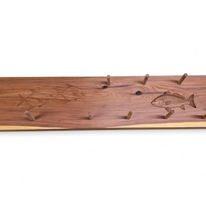 May include: A rectangular wooden wall rack featuring a natural grain pattern with live edges. The surface is decorated with laser-engraved fish illustrations and includes ten small wooden pegs arranged in two rows for hanging items.