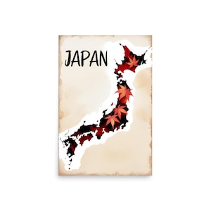 Op de afbeelding: Een poster met een kaart van Japan, omlijnd in wit, met een rood en zwart interieur. Het woord "JAPAN" is in zwart schrift geschreven. Rode esdoornbladeren zijn in het kaartontwerp geplaatst.