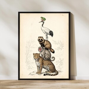 May include: A framed art print featuring a vertical stack of animals on a cream background. A leopard sits at the base, supporting a macaque, a raccoon dog, and a crane, with a small green frog perched on the crane's head. Faint line art of bamboo and cherry blossoms surrounds the animals.