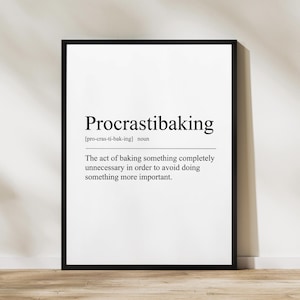 May include: A framed print with the word "Procrastibaking" in a bold, serif font. Below, the definition reads: "The act of baking something completely unnecessary in order to avoid doing something more important."