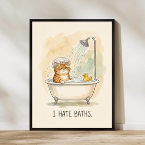 Könnte beinhalten: Gerahmter Druck mit einer Illustration einer orangefarbenen Tabby-Katze in einer Badewanne, die eine Duschhaube trägt, mit einem Duschkopf und einer Quietscheente. Der Text "I HATE BATHS" steht unter der Wanne.