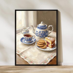 Op de afbeelding: Een ingelijst schilderij van een theetafereel met een blauw-witte theepot, kop en schotel. Een bord met koekjes en een stuk cake met jam staan ook op tafel. De scène speelt zich af bij een raam met zacht licht.