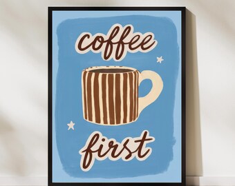 May include: A framed art print with a blue background and the words "coffee first" in a cursive font. A brown and white striped coffee mug is in the center. Two small white stars are also on the blue background.